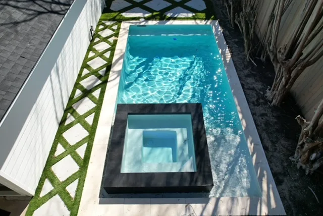 Modern pool and spa with turf pavers aerial view