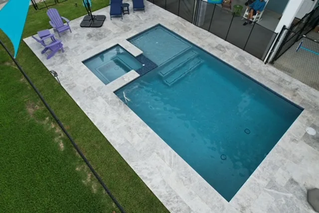 Geometric pool with spa and shade sail aerial view