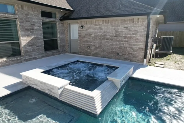 Raised spa with brick veneer and spillover detail