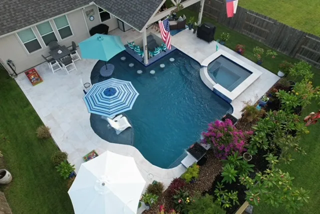 Freeform pool with tanning ledge, spa, and landscaping in Houston, TX