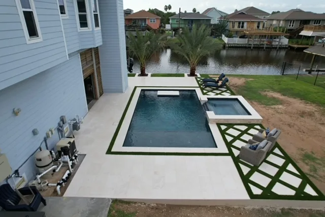 Waterfront pool with palm trees and turf pavers