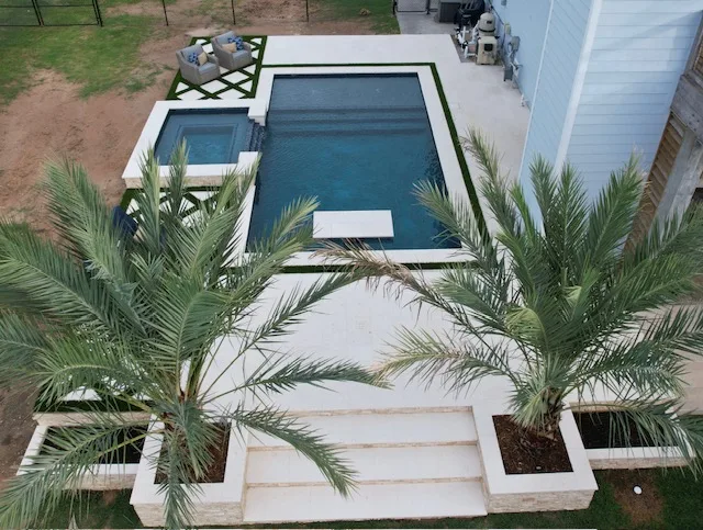 Geometric pool with palm trees and turf aerial view