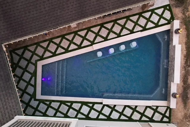 Pool with LED lighting at night aerial view