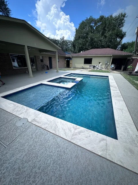 Rectangular pool with spa under covered patio