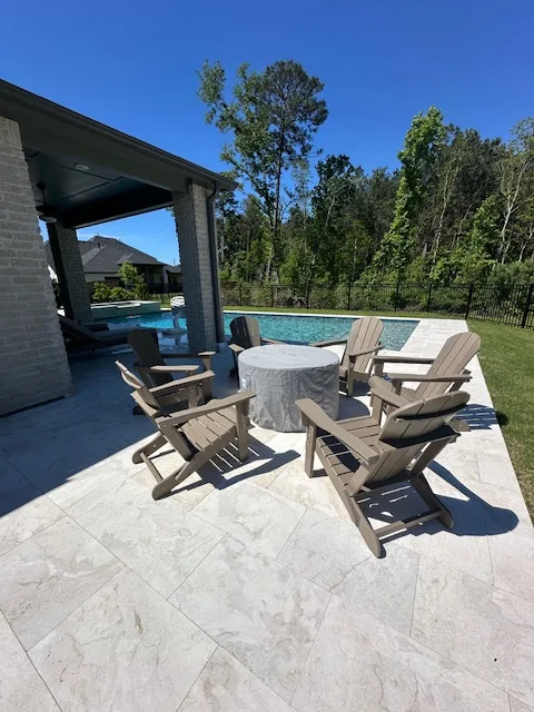 Patio seating area with Adirondack chairs beside pool