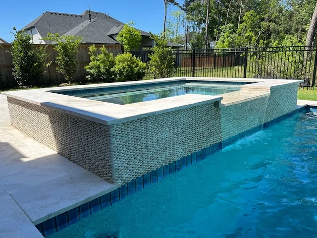 Raised spa with tile spillover into pool