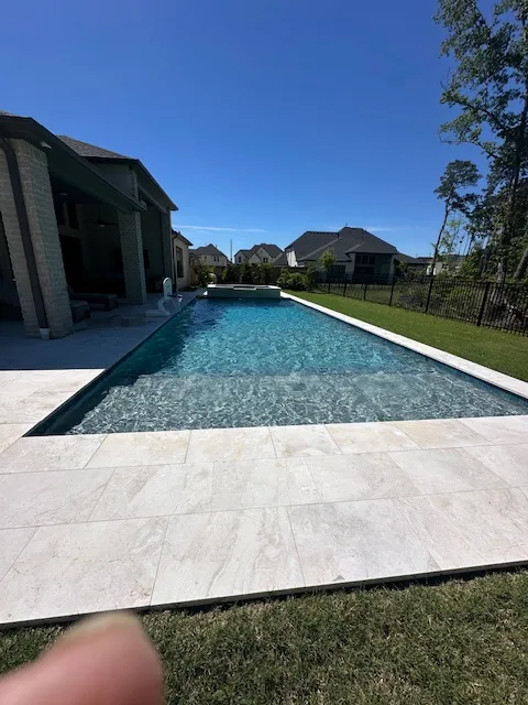 Long rectangular pool with travertine deck and spa