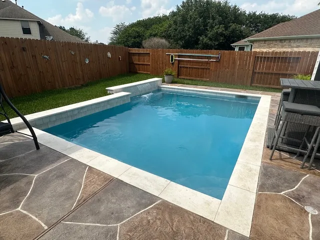 Rectangular pool with raised wall and water feature