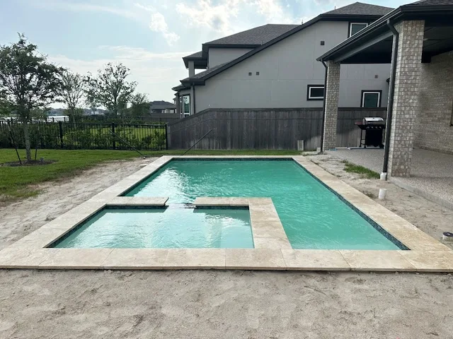 Geometric pool with attached spa in new construction