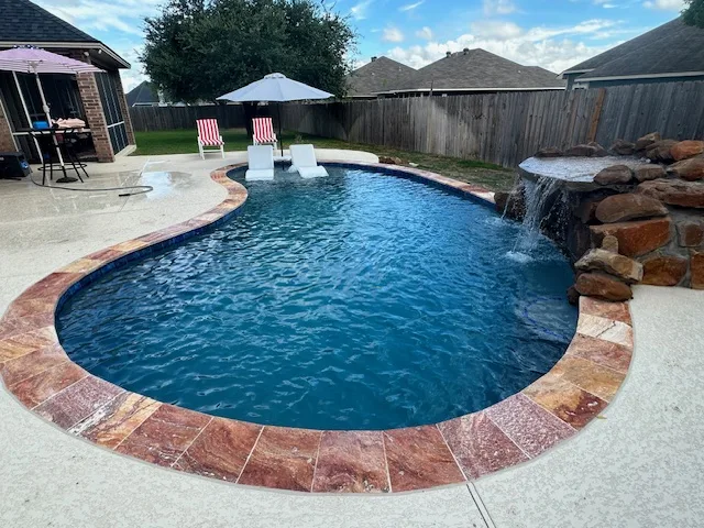Freeform pool with rock waterfall and tanning ledge