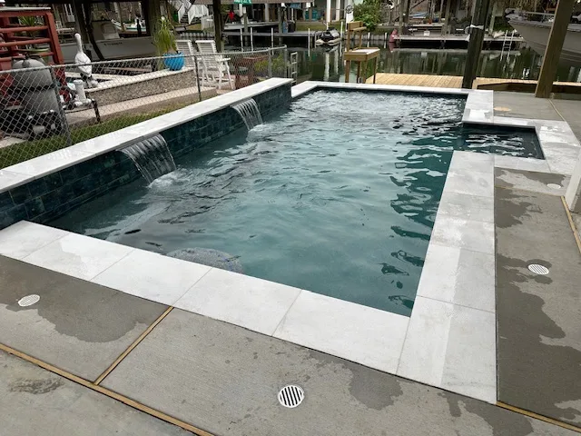 Pool with wall-mounted water features and spillovers